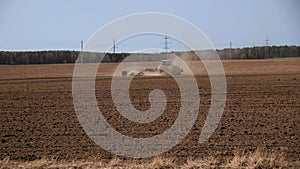 tractor cultivator or seeder plows the land, prepares for crops. dust on field