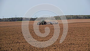 tractor cultivator or seeder plows the land, prepares for crops. dust on field