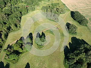 Tractor cut grass haymaking on farmland field, aerial view