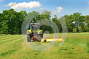 Tractor cutting grass meadow