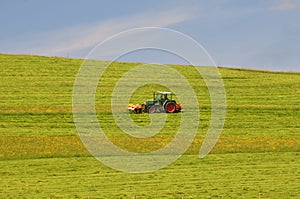 Tractor cutting meadow