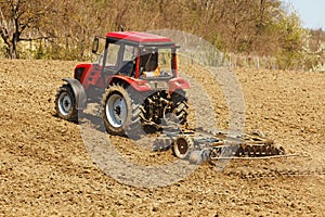 Tractor with disk harrow and rake