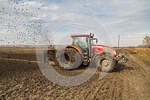 Tractor with double wheeled ditcher digging drainage canal