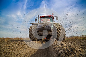 Tractor with double wheeled ditcher digging drainage canal