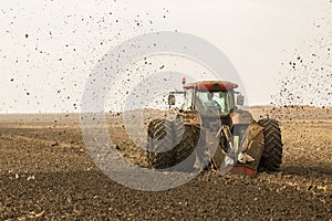 Tractor with double wheeled ditcher digging drainage canal