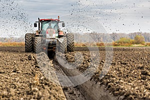 Tractor with double wheeled ditcher digging drainage canal