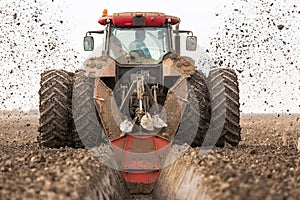 Tractor with double wheeled ditcher digging drainage canal