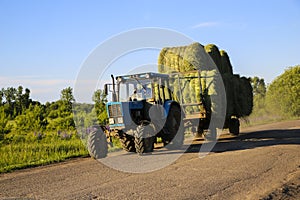 Tractor driven fresh hay rolled, after seasonal harvesting