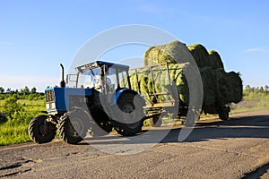 Tractor driven fresh hay rolled, after seasonal harvesting