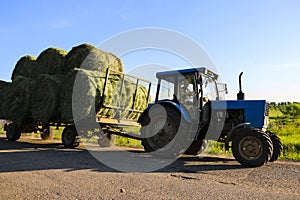 Tractor driven fresh hay rolled, after seasonal harvesting