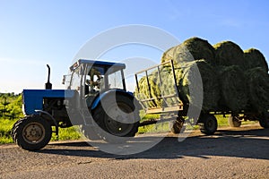 Tractor driven fresh hay rolled, after seasonal harvesting