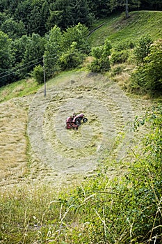 Tractor driver mows the meadow, Stiavnica Mountains, Slovakia