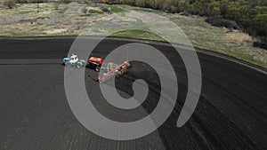 tractor drives across the field and plows the land. aerial shooting