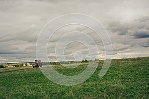 A tractor drives along a rural road along a green field