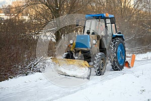 Tractor driving down a snow covered road