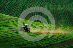 The tractor is driving in the field. Agrotechnics in the field working