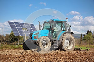 Tractor farming in field and solar panel