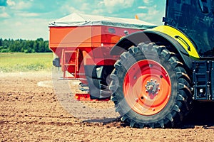 Tractor fertilize the field with granular fertilizer photo
