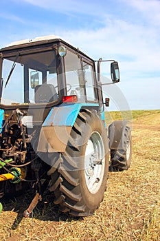 Tractor in a field, agricultural scene in summer