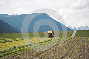 A tractor on a field in front of mountain