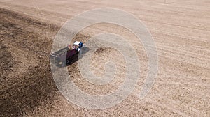 Tractor on the field makes organic fertilizers aerial survey with a drone