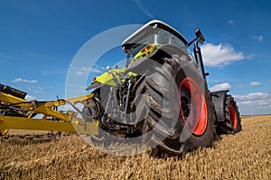 tractor in a field with stubble trailed equipment, bottom view