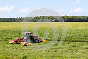 Tractor on the field, surrounded by storks photo