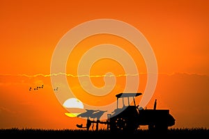 Tractor in the fields at sunset