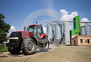 Tractor in front of silos