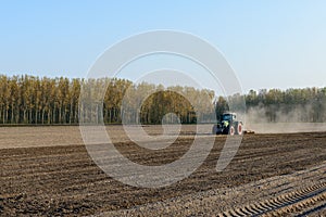 Tractor harrowing rice field, Lomellina (Italy) photo