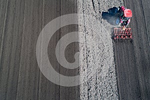 Tractor harrowing soil in spring photo