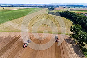 Tractor harrownig the large brown field