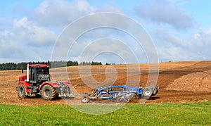 Tractor harrows the ground in the village
