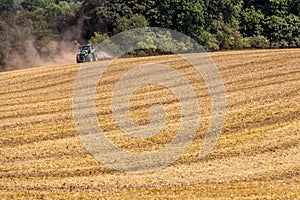 Tractor harvester working in wheat field in summer time