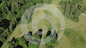 Tractor haymaking grass in summer, aerial