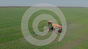 Tractor with hinged system of spraying pesticides. Fertilizing with a tractor, in the form of an aerosol, on the field