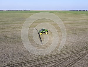 Tractor with hinged system of spraying pesticides. Fertilizing with a tractor, in the form of an aerosol, on the field of winter w