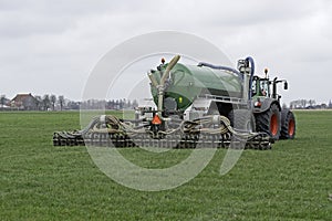 Tractor injects liquid manure in a meadow photo