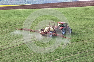 Tractor irrigate a field in South Moravia at sunset, beautiful view with yellow flowers, yellow field and green grass, Czech Repub