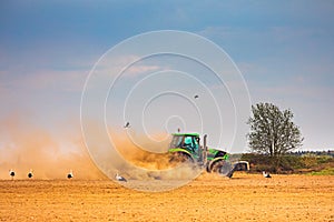 Tractor kicking up dust cloud in a drought conditions in Lithuania