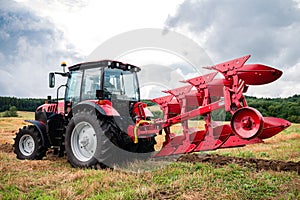 tractor with a large plow is ready to work in the field