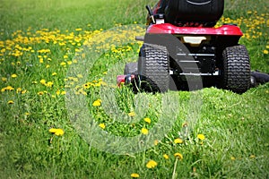 Tractor lawn mower cutting the grass in springtime