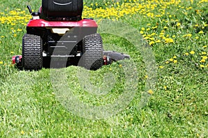 Tractor lawn mower cutting the grass in springtime