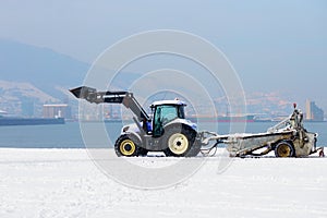 Tractor machine cleaning snow