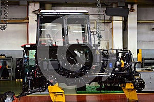 Tractor Manufacture work. Assembly line inside the agricultural machinery factory.