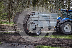 A tractor with a manure spreader to spread organic composted green waste