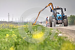 Tractor with a mechanical mower mowing grass