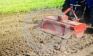 Tractor with milling machine loosens, grinds and mixes ground. Grinding and loosening soil, removing plants and roots from past photo