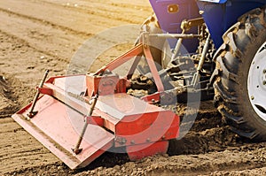 Tractor with milling machine loosens, grinds and mixes soil. Loosening the surface, cultivating the land for further planting.