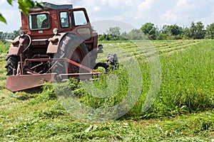 Tractor mounted rotary mower during operation on hayfield